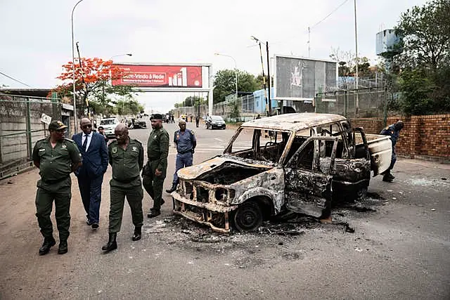 Border officials inspect a burnt-out Mozambican border patrol vehicle