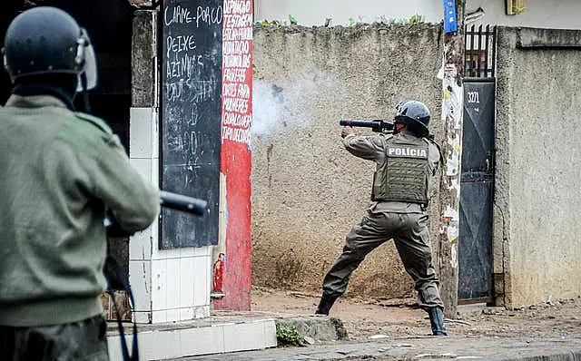 A police officer aims his weapon