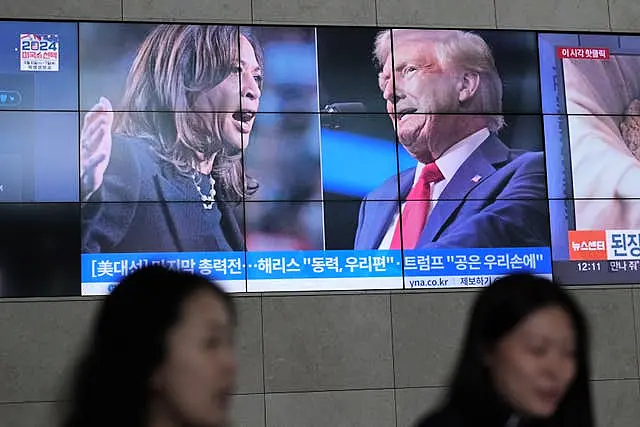 A screens shows images Kamala Harris and Donald Trump 