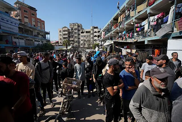 Palestinians gather to receive aid distributed by UNRWA