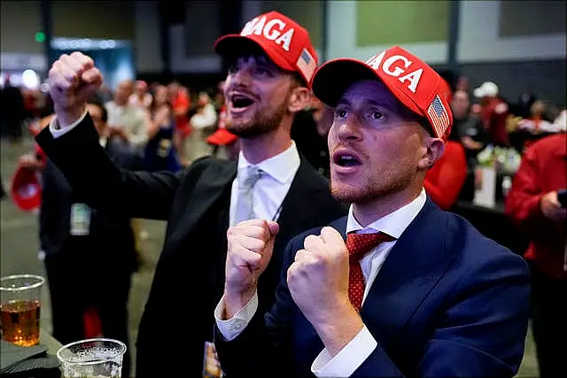 Donald Trump supporters in suits and Maga hats celebrating