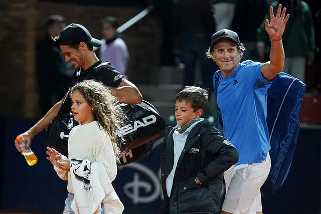 Diego Forlan, right, waves as he leaves the court