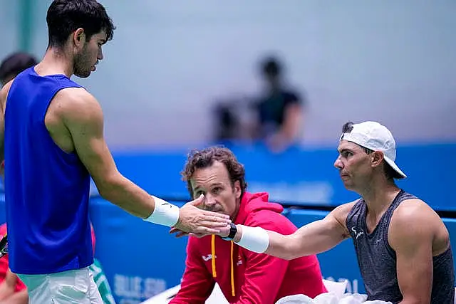 Carlos Alcaraz, left, taps hands with team-mate Rafael Nadal 