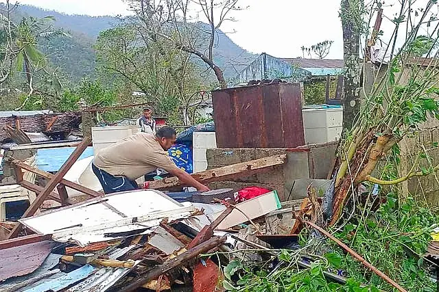 A resident recovers belongings from their damaged home caused by Typhoon Man-yi 