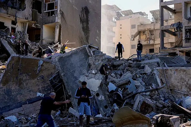 Residents check the site of an Israeli air strike in Tayouneh, Beirut, Lebanon