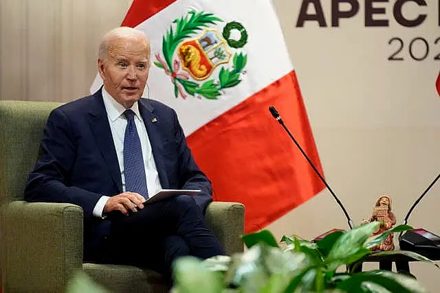 Joe Biden sat before a Peruvian flag