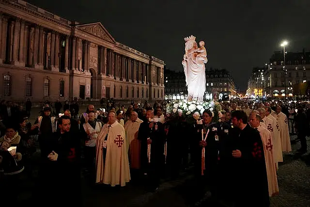 A replica of the Virgin Mary statue is carried from Saint-Germain l’Auxerrois church to Notre-Dame cathedral during a procession in Paris