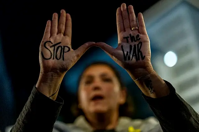 A woman with 'stop the war' written on her hands