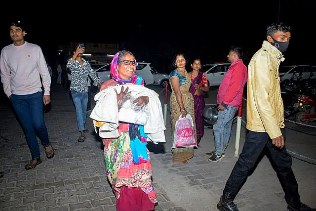 A woman rushes a child to the emergency ward 