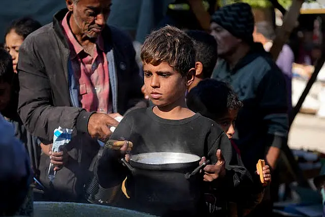 A Palestinian child queues for food in Deir al-Balah in the Gaza Strip 