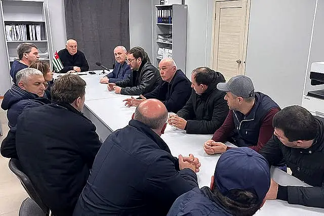 Aslan Bzhania, background second left, speaks to Abkhazian politicians 