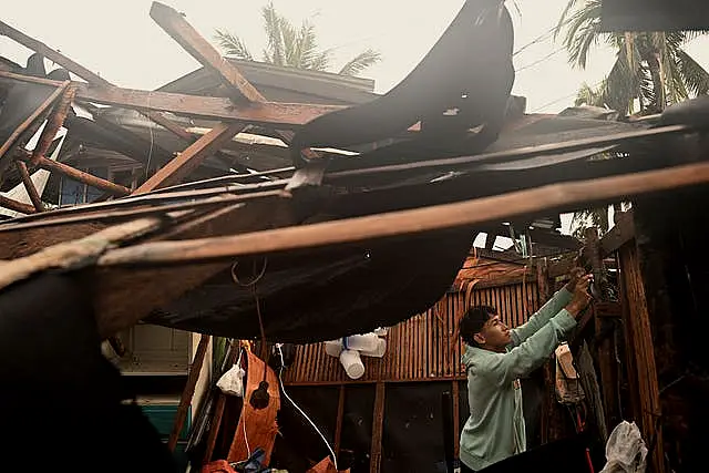 A resident checks belongings from his damaged home in the municipality of Baler, Aurora province, northeastern Philippines 