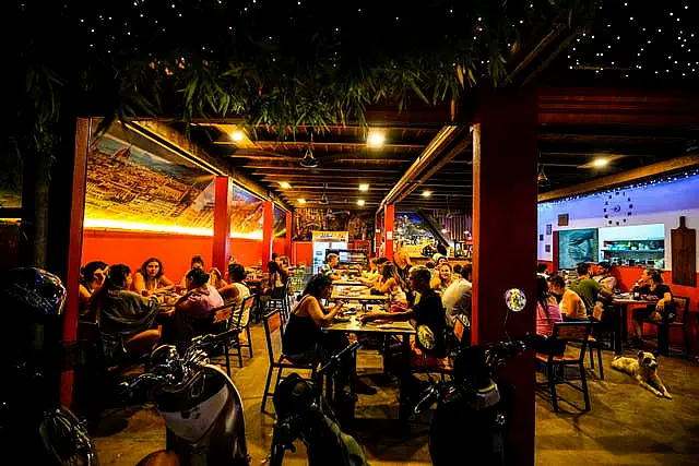 Foreign tourists have a drink at a night club at Nana Backpack hostel in Vang Vieng, Laos