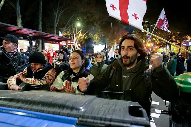 Protesters standing behind a barricade during a rally in Tbilisi 