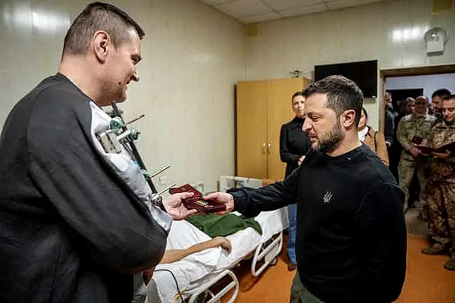 Ukraine’s President Volodymyr Zelensky, right, awards honor medals to soldiers during his visit to a military hospital in Kyiv,