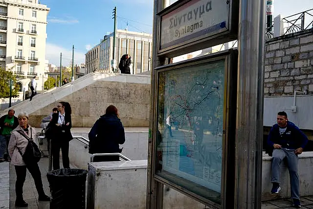 Commuters stand outside the closed main metro Syntagma station