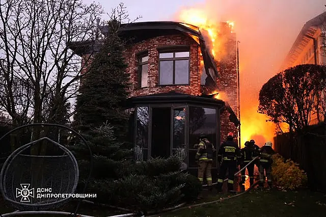 Rescue workers put out a fire at a house damaged by a Russian strike 