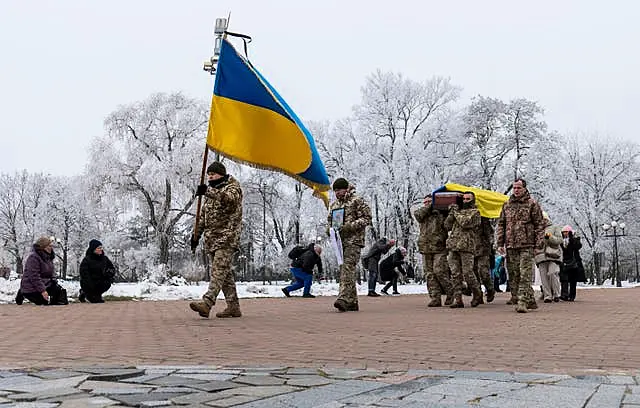 Fellow Ukrainian soldiers carry the coffin of a man who was killed in a battle with Russian troops