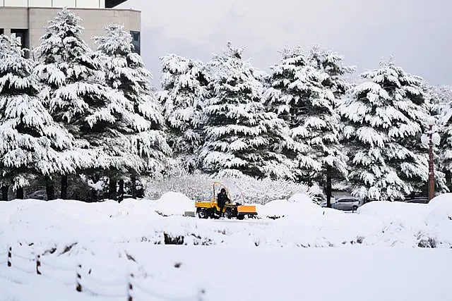 A worker uses a tractor to remove the snow at the National Assembly