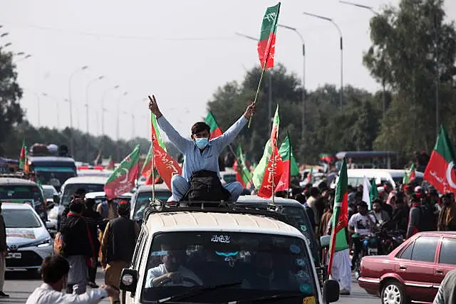 Supporters board vehicles as they start a rally 