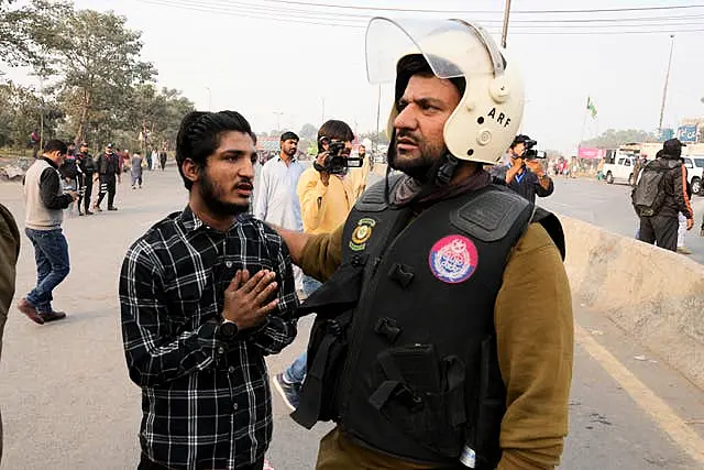 A police officer detains a supporter of imprisoned former premier Imran Khan’s Pakistan Tehreek-e-Insaf party,