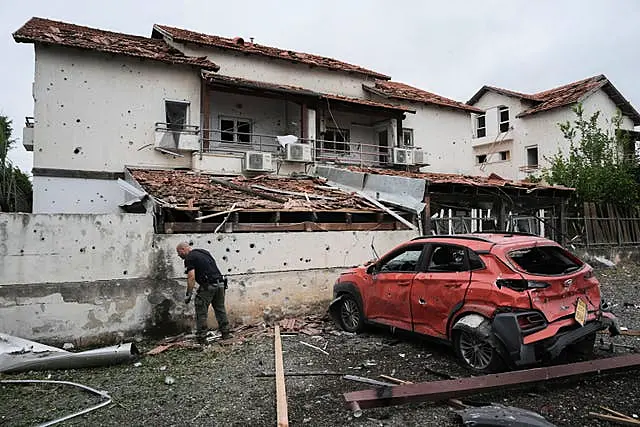 Man examines missile damage at house