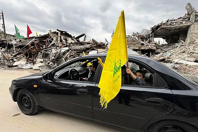 A boy holds a Hezbollah flag