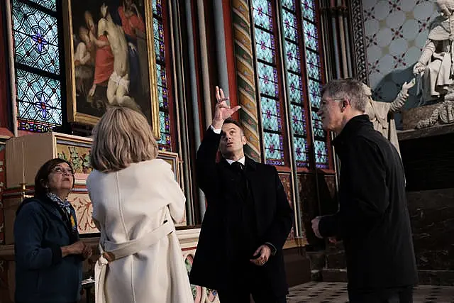 French President Emmanuel Macron looks around the cathedral 