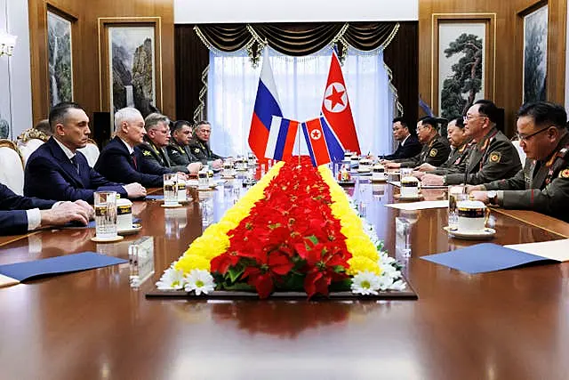 Russia's Andrei Belousov speaks across a table to North Korean defence minister No Kwang Chol