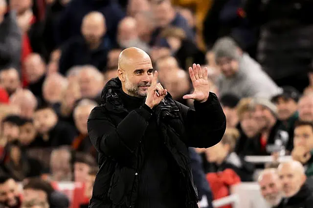 Pep Guardiola holds up six fingers, one for each Premier League title he has won, as he responds to the Liverpool fans at Anfield