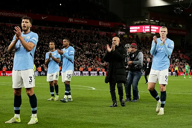 Pep Guardiola and his Manchester City players applaud their fans after defeat at Liverpool