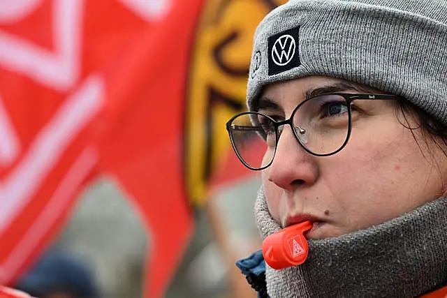 A Volkswagen worker blows a whistle