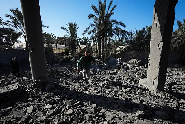 A Palestinian inspects the rubble of a destroyed building