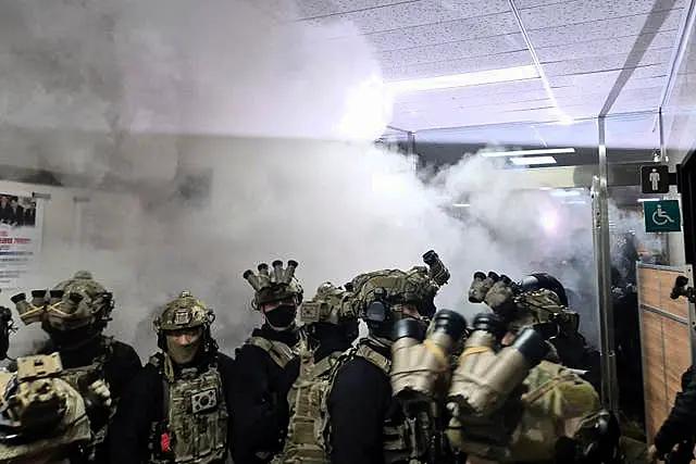 A National Assembly staff sprays fire extinguishers to block soldiers entering the main hall of the National Assembly in Seoul, South Korea