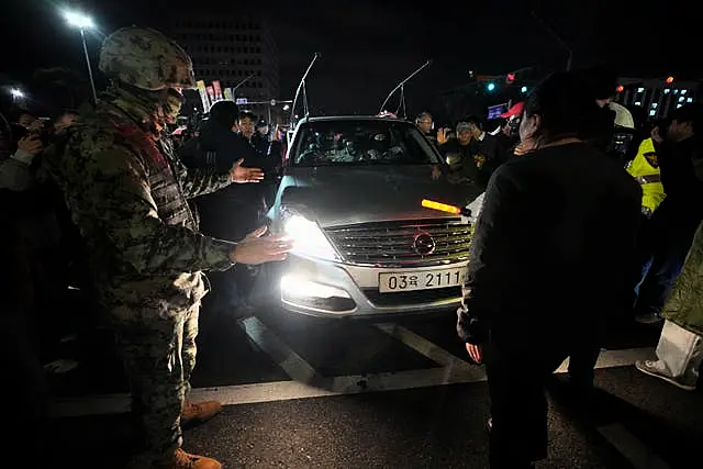 People block a martial law vehicle as they gather to demand South Korean President Yoon Suk Yeol to step down in front of the National Assembly in Seoul, South Korea