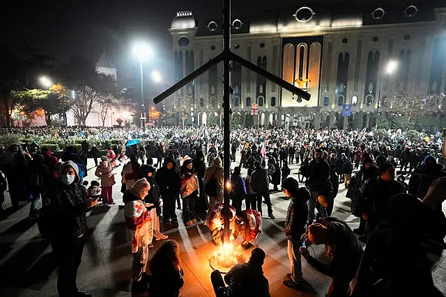 Demonstrators light candles during a rally 