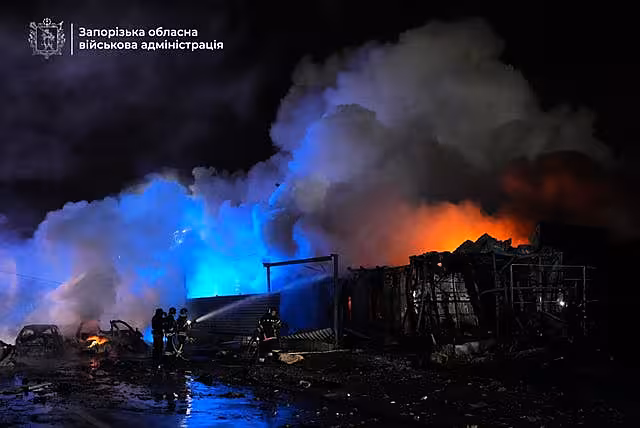 In this photo provided by Zaporizhzhia Military Administration, firefighters extinguish a fire following a Russian attack