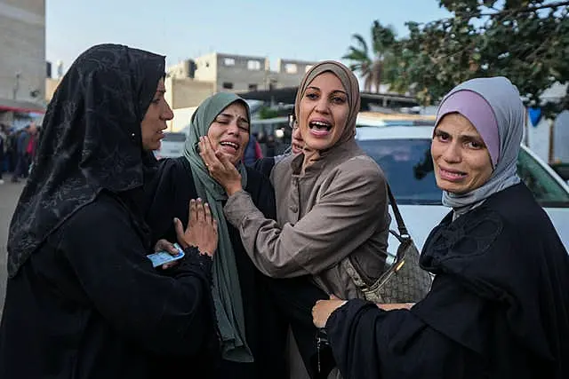 Palestinian women mourn over victims following an Israeli bombardment, at the Al-Aqsa Martyrs hospital in Deir al-Balah, Gaza Strip