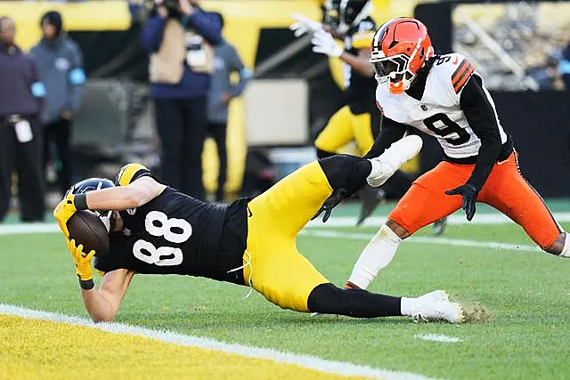 Pittsburgh Steelers tight end Pat Freiermuth scores in front of Cleveland Browns safety Grant Delpit