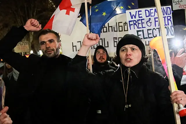 Demonstrators carrying a Georgian national flag and an EU flag gather in front of Parliament to protest against the government's decision to suspend European Union accession negotiations in Tbilisi.