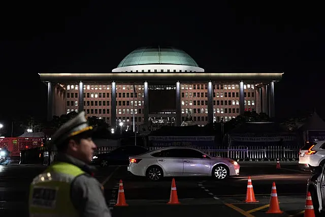 Um policial de trânsito caminha perto da Assembleia Nacional enquanto ocorre uma manifestação exigindo o impeachment do presidente sul-coreano Yoon Suk Yeol, em Seou