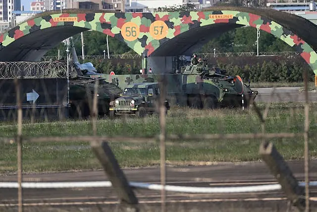 Taiwan army ground force members ride on vehicles at an airbase in Hsinchu, northern Taiwan