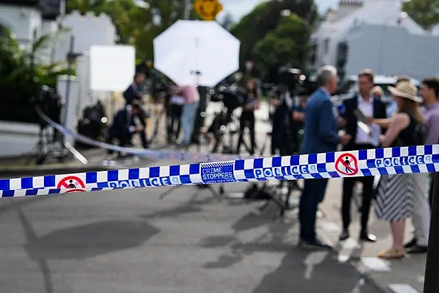 Media wait outside a police cordon at a street where houses were vandalised with anti-Israel slogans