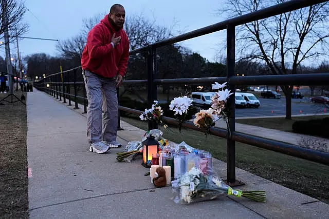 A person who did not wish to give his name places flowers outside the Abundant Life Christian School