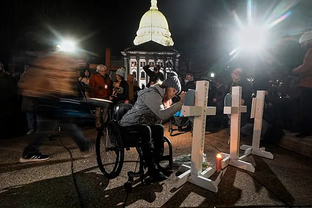 A supporter signs a cross during a candlelight vigil outside the Wisconsin Capitol in Madison 