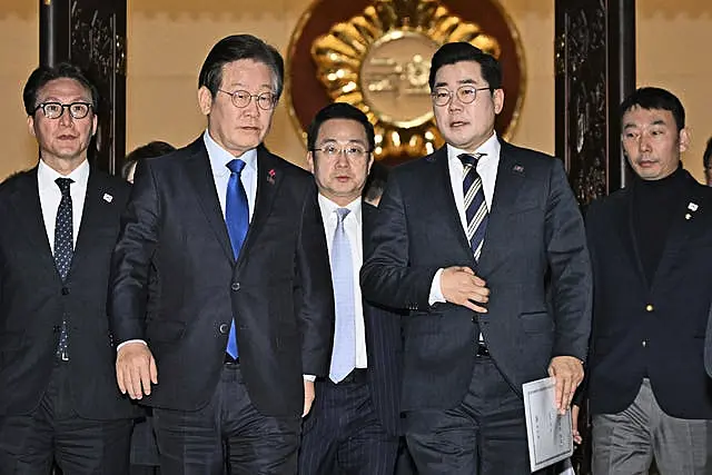 South Korea’s main opposition Democratic Party leader Lee Jae-myung, front left, and its floor leader Park Chan-dae, front right, leave a room at the National Assembly in Seoul after South Korea’s parliament voted to impeach President Yoon Suk Yeol