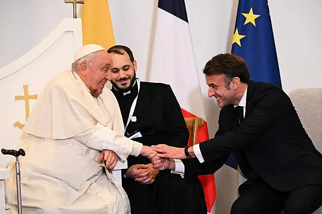 Pope Francis shakes hands with French President Emmanuel Macron