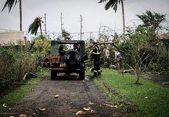 Soldiers and rescue workers clearing a street in the French territory of Mayotte in the Indian Ocean after Cyclone Chido 