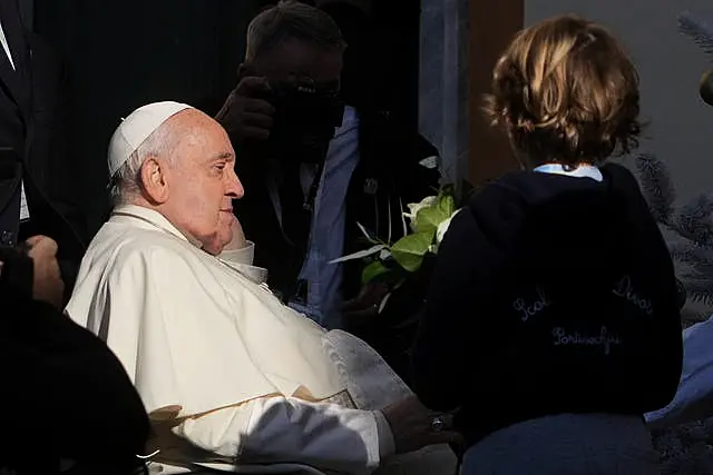 Pope Francis being presented with flowers by a child