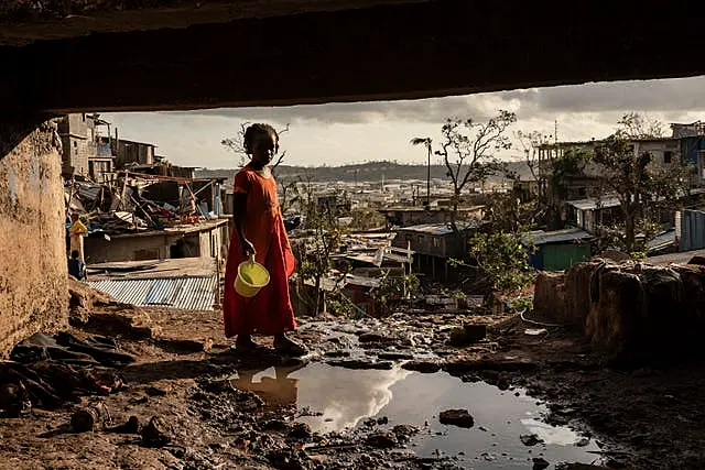 A young girl stands amid the devastation after Cyclone Chido